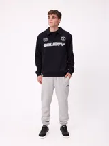 Buzo tipo polo de manga larga color bordó, con cuello camisero y cierre frontal de botones. Presenta estampado gráfico frontal con el número 85, el logo de la marca Rusty y un escudo deportivo.