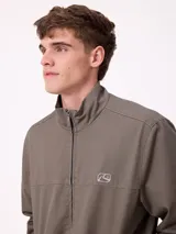 Campera Rusty de corte clásico, color negro, con cierre frontal completo, cuello alto y puños elásticos. Presenta un diseño minimalista con el logo de la marca bordado en el pecho.