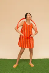 Vestido corto sin mangas con cuello redondo y estampado a rayas verticales en azul, verde y rojo.