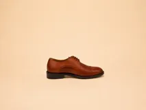 Zapato de vestir tipo oxford de cuero negro con puntera reforzada y cordones al tono.