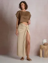 Blusa corta de lino marca Elan, de corte crop con silueta holgada, hombros caídos, escote amplio a la base y aberturas laterales ajustables con lazos para anudar.