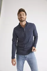 Polo de manga larga para hombre, con diseño a rayas horizontales blancas sobre fondo azul marino. Presenta cuello clásico, cierre frontal con botones y logo bordado en el pecho.