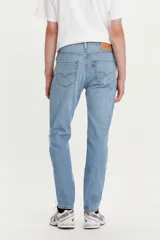 Pantalón jean 511 Slim Fit de corte entallado, tiro medio y color celeste claro con roturas en la rodilla izquierda.