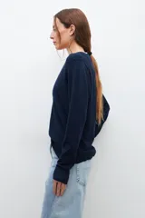 Sweater crudo de tejido de punto, con escote en V y mangas largas.