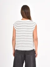 Remera sin mangas de corte holgado, con cuello redondo y diseño de rayas horizontales finas en color negro sobre fondo blanco.