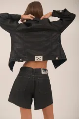 Short de jean negro con proceso de encuerado y terminaciones desflecadas.