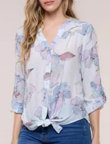 Blusa Hope & Harlow de gasa estampada con patrón floral en tonos azul y blanco, escote en V con botones frontales, mangas largas regulables y nudo decorativo en el ruedo.