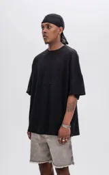 Remera negra de manga corta con calce extra oversize y recorte horizontal en el delantero y la espalda.