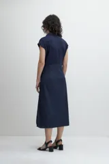 Vestido camisero midi azul marino con cuello, mangas cortas, cierre frontal con botones y cinto del mismo material.