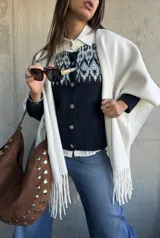 Cardigan de punto en color azul marino con diseño jacquard en tonos celestes y blancos en la parte superior. Presenta cuello redondo, cierre frontal con botones y mangas largas.
