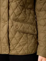 Campera acolchada de diseño matelassé, color negro, con cuello alto, cierre frontal con cremallera y botones a presión, y bolsillos delanteros con solapa.