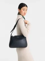 Cartera hobo Longchamp modelo Le Pliage Xtra, de cuero color negro, con solapa frontal con botón a presión y correa ajustable para el hombro.