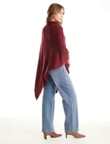 Poncho tejido de punto con diseño asimétrico y cuello redondo, confeccionado en material suave.