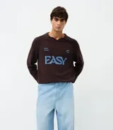 Pantalón de jean corte baggy, de tiro alto y pierna ancha, con diseño de cinco bolsillos, trabillas para cinturón y cierre frontal con botón y cremallera.