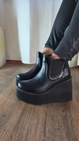 Botas cortas de cuero color suelo y negro con detalles en animal print de leopardo, con plataforma y taco cuña tricolor en negro, blanco y suela. Incorpora elásticos laterales estilo chelsea.