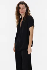 Blusa celeste con escote en V, mangas cortas y detalle desflecado en mangas y ruedo.