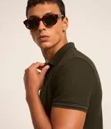 Remera polo blanca de viscosa texturizada con rayas, cuello y puños de mangas cortas en ribana con detalles contrastantes en negro.