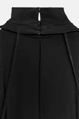 Vestido largo de corte evasé, con cuello subido y diseño sin mangas. Presenta cierre en la espalda con botones y una caída fluida.