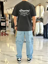Remera oversize gris con efecto acid wash, de mangas cortas y cuello redondo, con estampado tipográfico blanco en la espalda.
