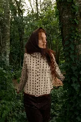 Cardigan reversible de punto con diseño de rombos pequeños, cuello redondo y cierre frontal con botones. Presenta un patrón bicolor en tonos bordó y rojo.