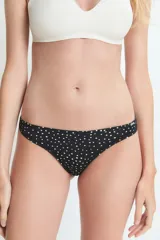 Bombacha tipo colaless de color negro con estampado de lunares blancos, confeccionada en poliamida y elastano con forro de algodón.