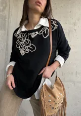 Sweater negro con diseño bordado en hilo crudo en el escote y el hombro, de manga larga y calce holgado.