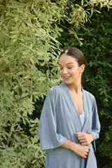 Bata estilo kimono de algodón en color gris azulado, con mangas al codo y largo por encima de la rodilla. Incluye lazo de ajuste en la cintura.