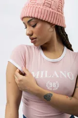 Remera ajustada de manga corta color marrón oscuro, con cuello redondo y ribetes blancos en el cuello y mangas. Presenta un estampado frontal en blanco con el texto "MILANO" y un escudo con el número "96".