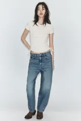 Camiseta corta de cuello redondo y manga corta, color gris oscuro, con frunces laterales ajustables mediante cordones.