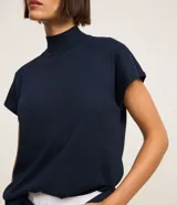 Blusa en punto texturizado color azul marino, con cuello alto acanalado, manga corta amplia, aberturas en los laterales de la parte baja y diseño de la marca Marfinno.