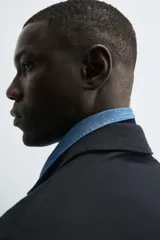 Sobrecamisa de corte relajado confeccionada en tejido de algodón con estructura de sarga. Presenta cuello solapa, cierre frontal con botonadura oculta, mangas largas con puños abotonados y dos bolsillos frontales tipo plastrón con solapa.