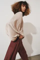 Blusa color beige confeccionada en viscosa, con cuello redondo y escote pico. Tiene mangas largas con puños y detalle de bordados con aplicación de abalorios en cuello, puños y ruedo. Diseño cruzado con fajín.