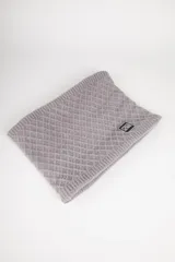 Cuello de lana color crudo con diseño de rombos en relieve y etiqueta negra con logo de la marca.
