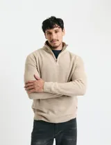 Sweater de punto inglés color verde, con cuello alto y cierre frontal parcial metálico. Diseño de manga larga con puños y ruedo acanalados.
