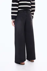 Jean de corte wide leg en color azul medio con efecto lavado. Presenta tiro medio, cierre frontal con botón y bolsillos laterales y traseros.