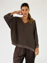 Blusa holgada color chocolate con escote en V y mangas largas con detalles en los puños y dobladillo.