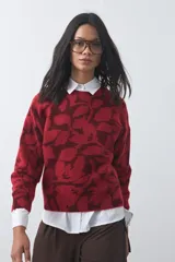 Sweater de punto con diseño estampado de hojas en tonos azul claro y azul oscuro. Presenta cuello redondo, mangas largas y terminaciones acanaladas en puños y ruedo.