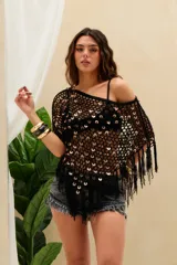 Top corto tejido en crochet color negro con diseño de red, aplicado con lentejuelas circulares metalizadas y flecos colgantes en el borde inferior y las mangas.