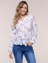 Blusa Zac & Rachel de manga larga con estampado floral en tonos azules y rosados, confeccionada en rayón y poliéster. Presenta cuello en V con botones frontales, bolsillo aplicado en el pecho y terminación anudada en la cintura.