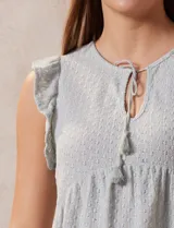 Blusa calada color celeste, marca Madden Girl. Cuello a la base, escote en V y lazo de ajuste. Sisa con volado.