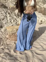 Pantalón ancho de tiro alto, color celeste claro, con costuras visibles en contraste que recorren verticalmente las piernas.