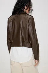 Cazadora biker de efecto piel en color marrón oscuro, con cuello de solapa, cierre frontal cruzado con cremallera, bolsillos laterales con cremallera y cinturón ajustable en el bajo.