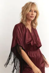 Mono largo de seda color celeste, con escote en V cruzado, mangas cortas amplias con flecos negros y cintura elastizada.