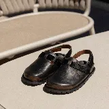 Zuecos de cuero marrón con tira de ajuste de velcro color borgoña.