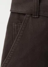 Enterito largo de algodón estilo tejano, color marrón, con cuello camisero, mangas cortas, cierre frontal con cremallera y cinturón ajustable en la cintura.