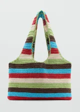 Bolso tipo shopper tejido en fibra natural con diseño de rayas horizontales multicolores. Cuenta con doble asa de hombro y estructura amplia sin cierre.