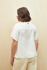 Blusa negra con textura, canesú con encaje, volados, corte fluido y mangas cortas amplias.