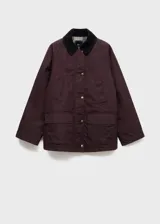 Parka de algodón color granate con cuello camisero de pana en contraste, cierre frontal de cremallera y botones, mangas largas con puños abotonados y bolsillos de parche con solapa en la parte delantera.