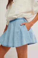 Falda pantalón de denim color celeste, de tiro medio y línea A. Cuenta con diseño de falda en la parte frontal y short incorporado en la parte trasera.