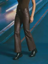 Pantalón de corte recto y tiro medio, confeccionado en material con acabado engomado efecto cuero. Presenta diseño de cinco bolsillos, cierre frontal con botón y costuras reforzadas.